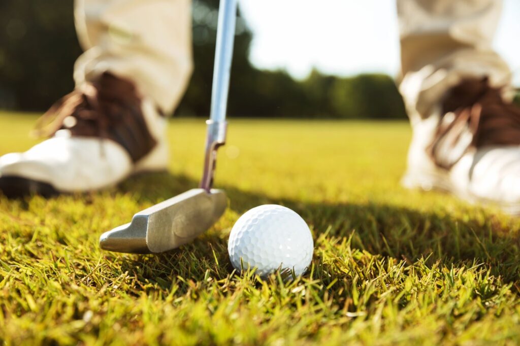 Close up of male golfer teeing off